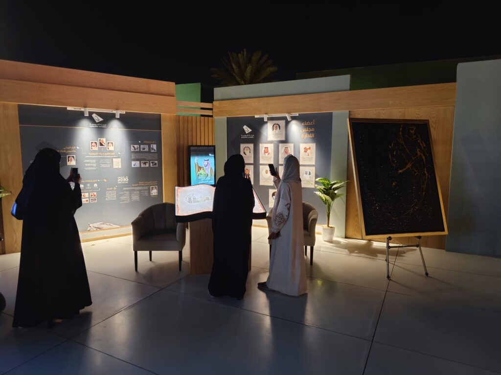 Visitors engaging with an interactive exhibit featuring a digital display and illuminated book, showcasing immersive audiovisual solutions designed to enhance storytelling and audience engagement at cultural events.