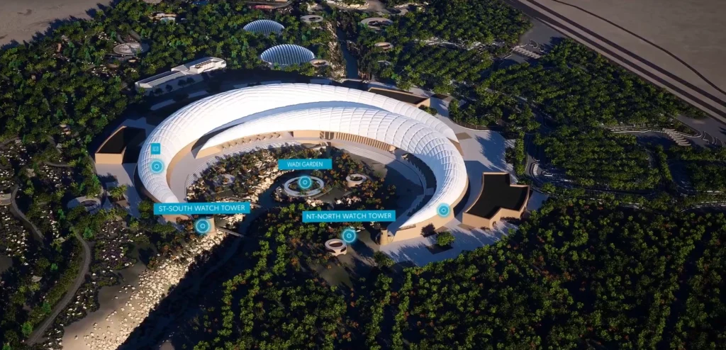 An aerial view of a futuristic architectural site surrounded by lush greenery, demonstrating the use of a digital twin in real estate. The image features interactive labels for elements such as watchtowers and gardens, showcasing how digital twins for real estate provide detailed visualization and insights into planning, design, and visitor engagement.