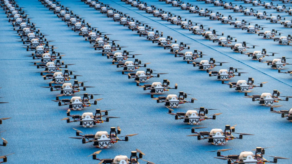 A stunning formation of drones arranged in precise rows, prepared for a coordinated drone show. The image highlights the integration of interactive technology and immersive solutions in modern events, showcasing how drones can enhance audience engagement through innovative displays.
