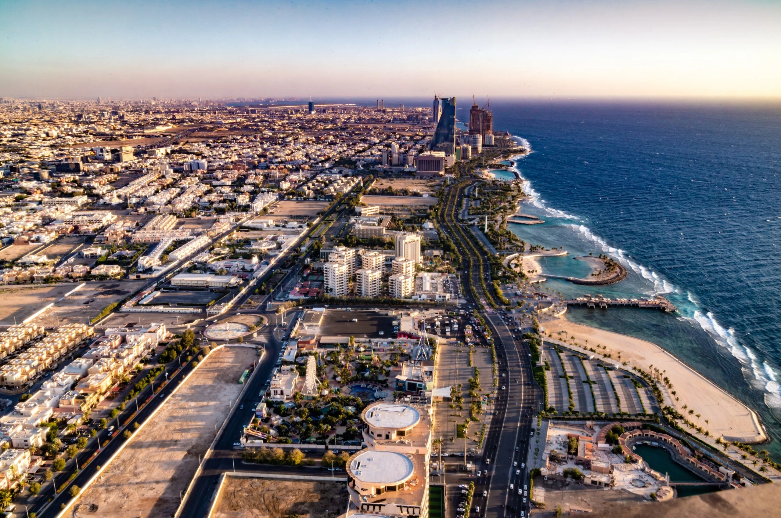 A stunning aerial view of Jeddah’s coastal skyline, showcasing modern architecture, vibrant urban development, and scenic waterfront spaces. As the city evolves, interactive spaces play a key role in enhancing the customer experience, offering immersive environments that blend technology, culture, and engagement to redefine urban living and retail interactions.