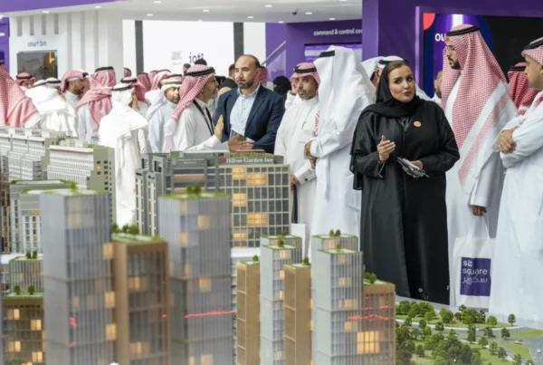 Cityscape Global attendees in traditional Saudi dress examining detailed scale models of future Riyadh real-estate developments.