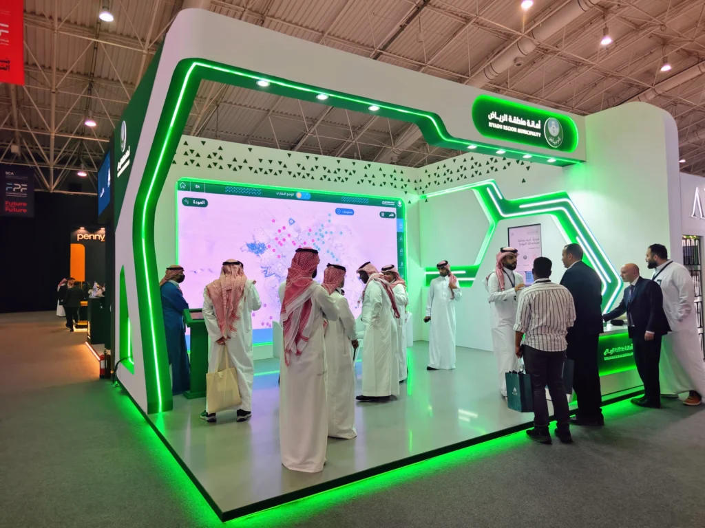 Attendees engaging with the Riyadh Digital Twin at the Riyadh Region Municipality stand during Future Projects Forum, interactive LED display and booth signage visible.
