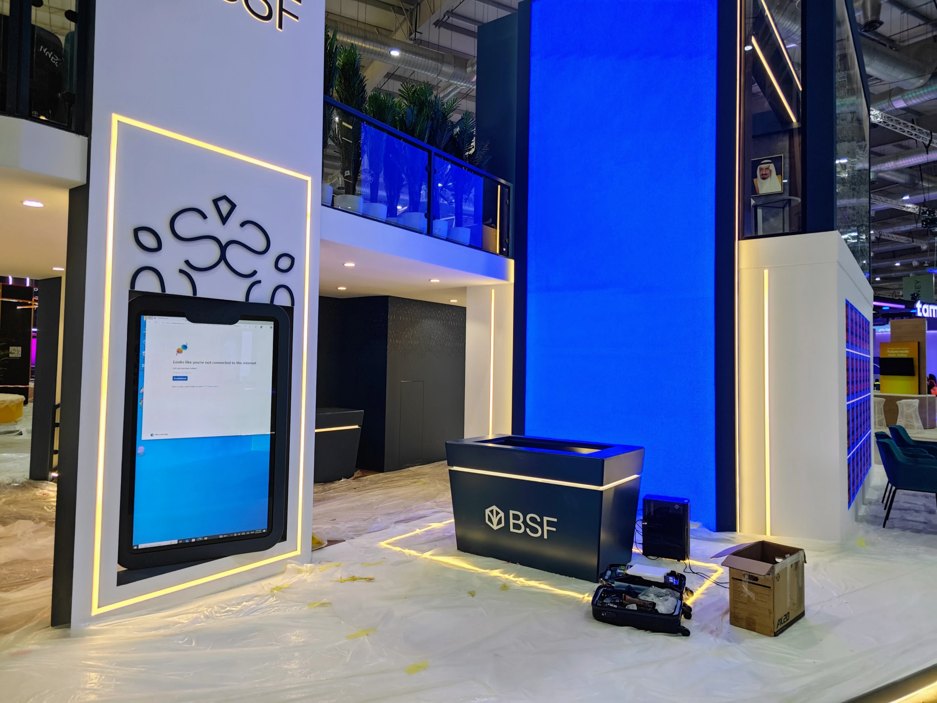 BSF booth pre-show setup at Money20/20 Riyadh with giant blue LED wall and vertical mobile-style screen awaiting network connection.