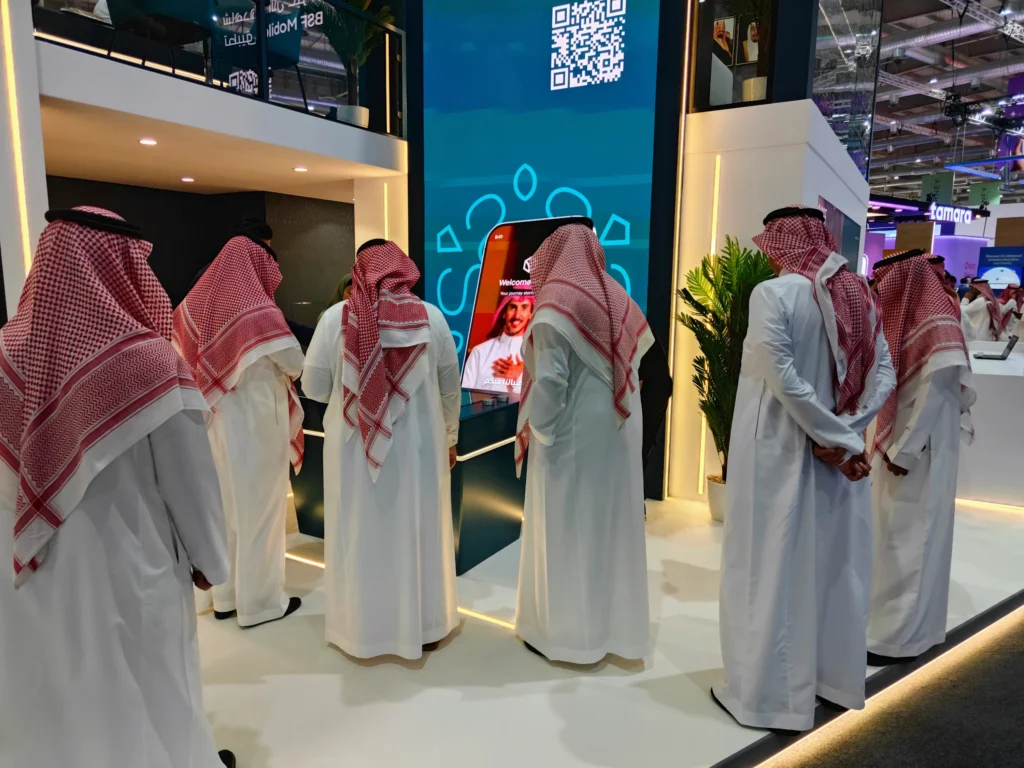 Visitors engaging with BSF’s giant vertical Mobile App Explorer interactive banking demo at Money20/20 Riyadh.
