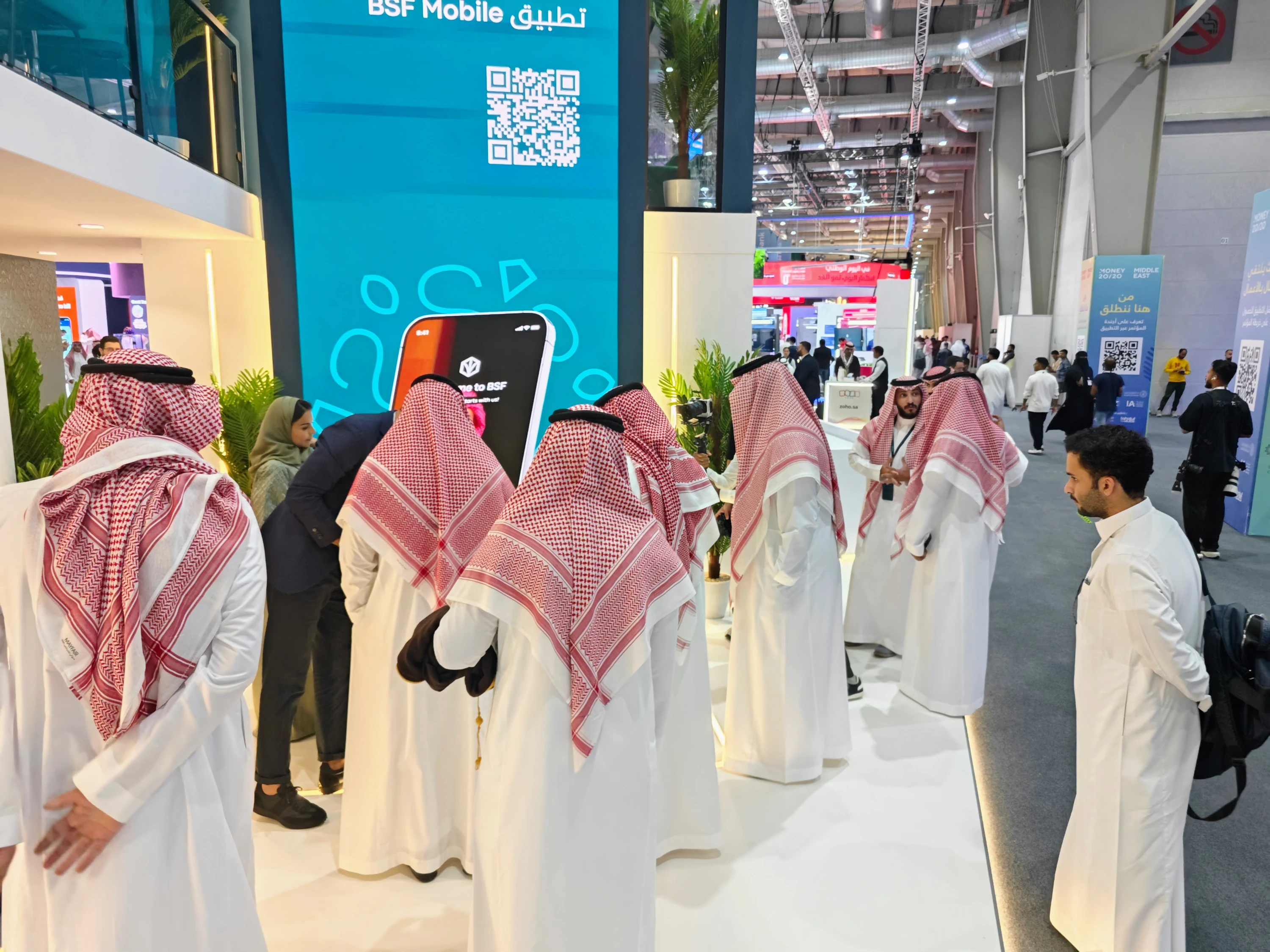 Crowd gathered around the BSF Mobile App Explorer with QR code wall live use-case walkthroughs at Money20/20 Riyadh.