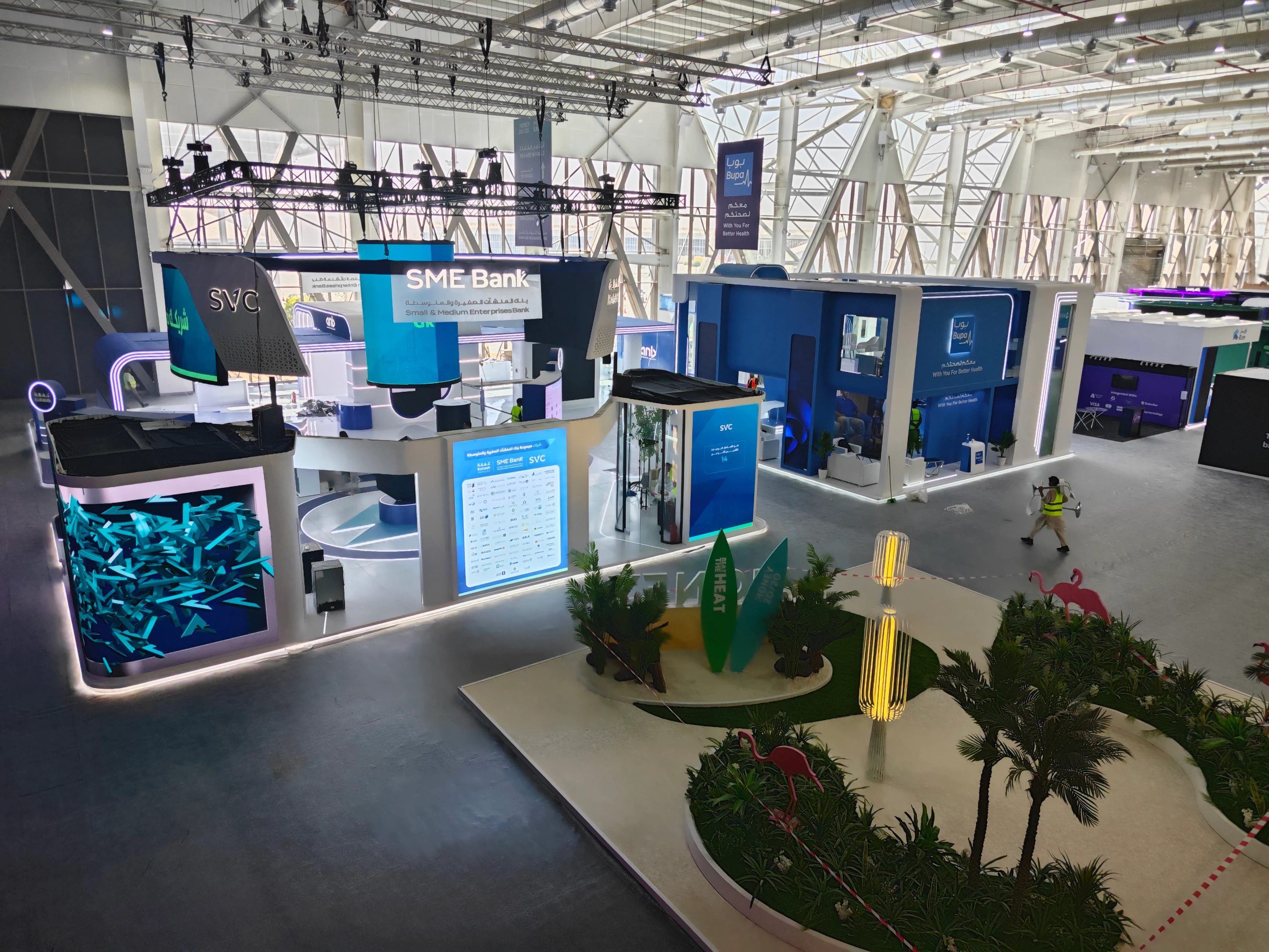 SME Bank and SVC pavilion with hanging signage, large digital displays, and clear wayfinding—modular layout optimized for flow and conversation zones.