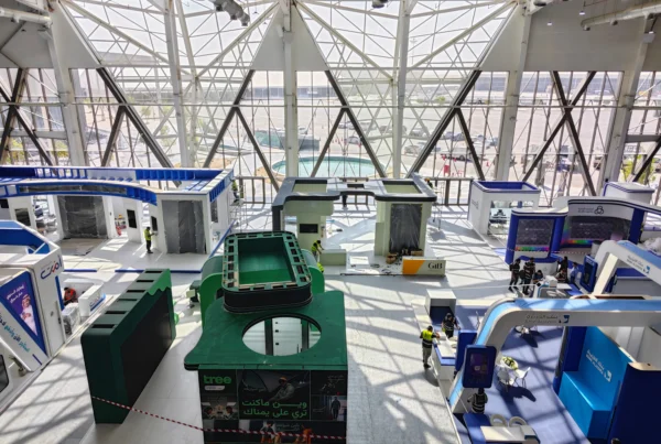 Overhead view of a large exhibition hall during build-up with modular booth structures—illustrating scalable, repeatable booth systems for 2026.